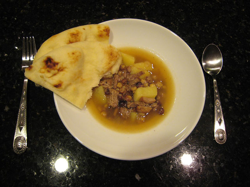 وعاء من حساء لحم الضأن من نافاجو مع الذرة الزرقاء. توجد قطعة من الخبز المسطح على جانب الوعاء.
