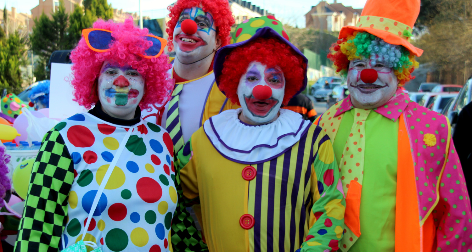 Quatre clowns professionnels debout ensemble en souriant.