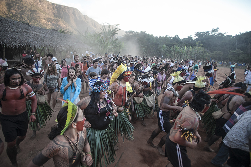 مجموعة متعددة الأعراق من الناس من منطقة الأمازون في احتفال خارجي. جميعهم يرتدون ملابس تقليدية.