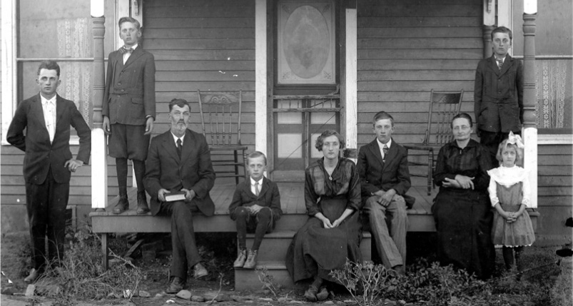 20 世纪初，一家九口坐在俄克拉荷马州科德尔的门廊上。