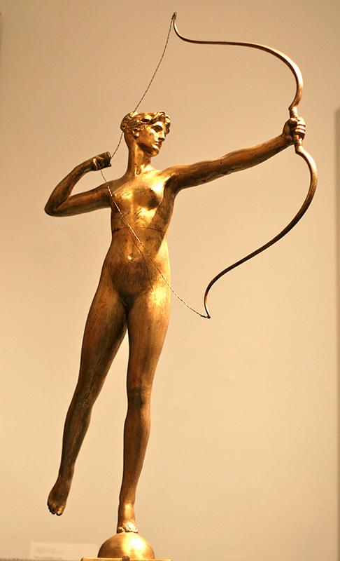 Uma estátua dourada de Diana, deusa romana da caça, ela está segurando um arco e tem a corda do arco puxada para trás.