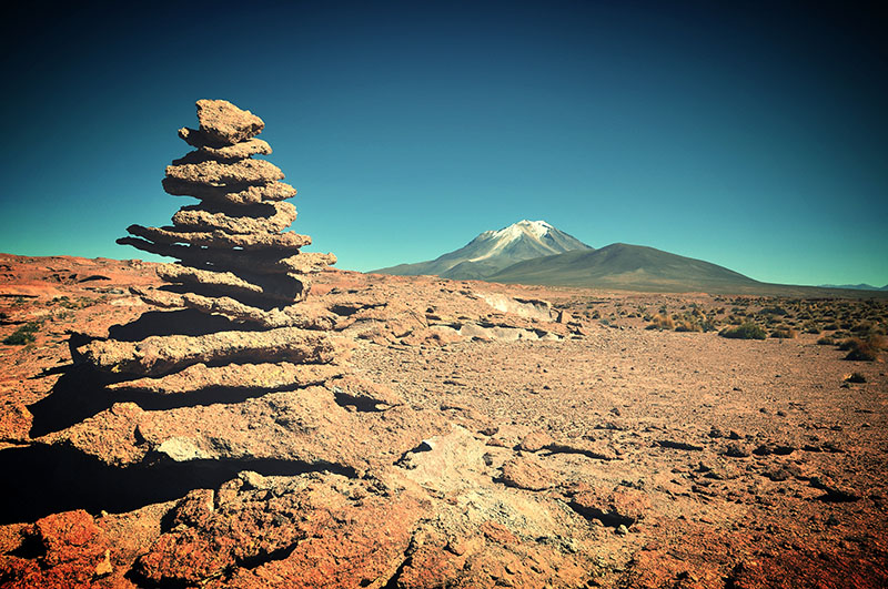 Une pile de rochers plats dans un paysage aride.