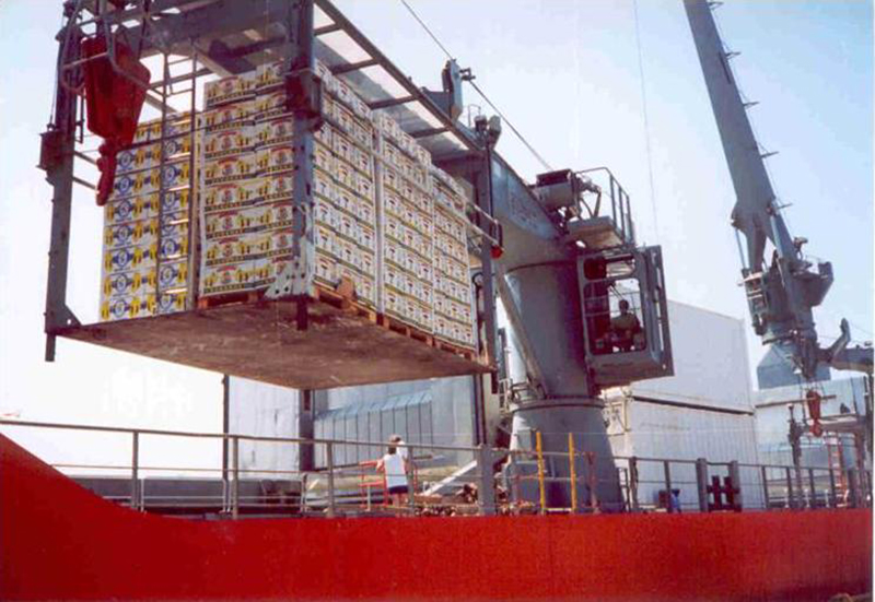 港口场景显示一台巨大的起重机将数百个托盘抬到船上。