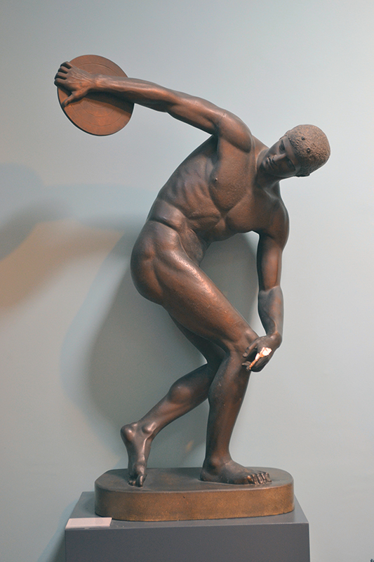 一个运动型男子在他身后伸出手臂把铁饼扔进手中的雕像。