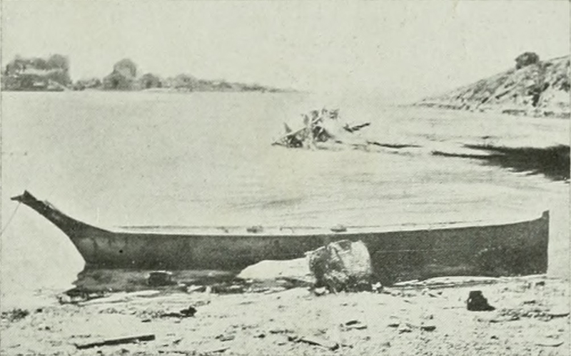 Imagem em preto e branco de uma canoa de madeira na praia.