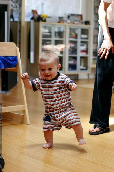 A baby walking unsupported.