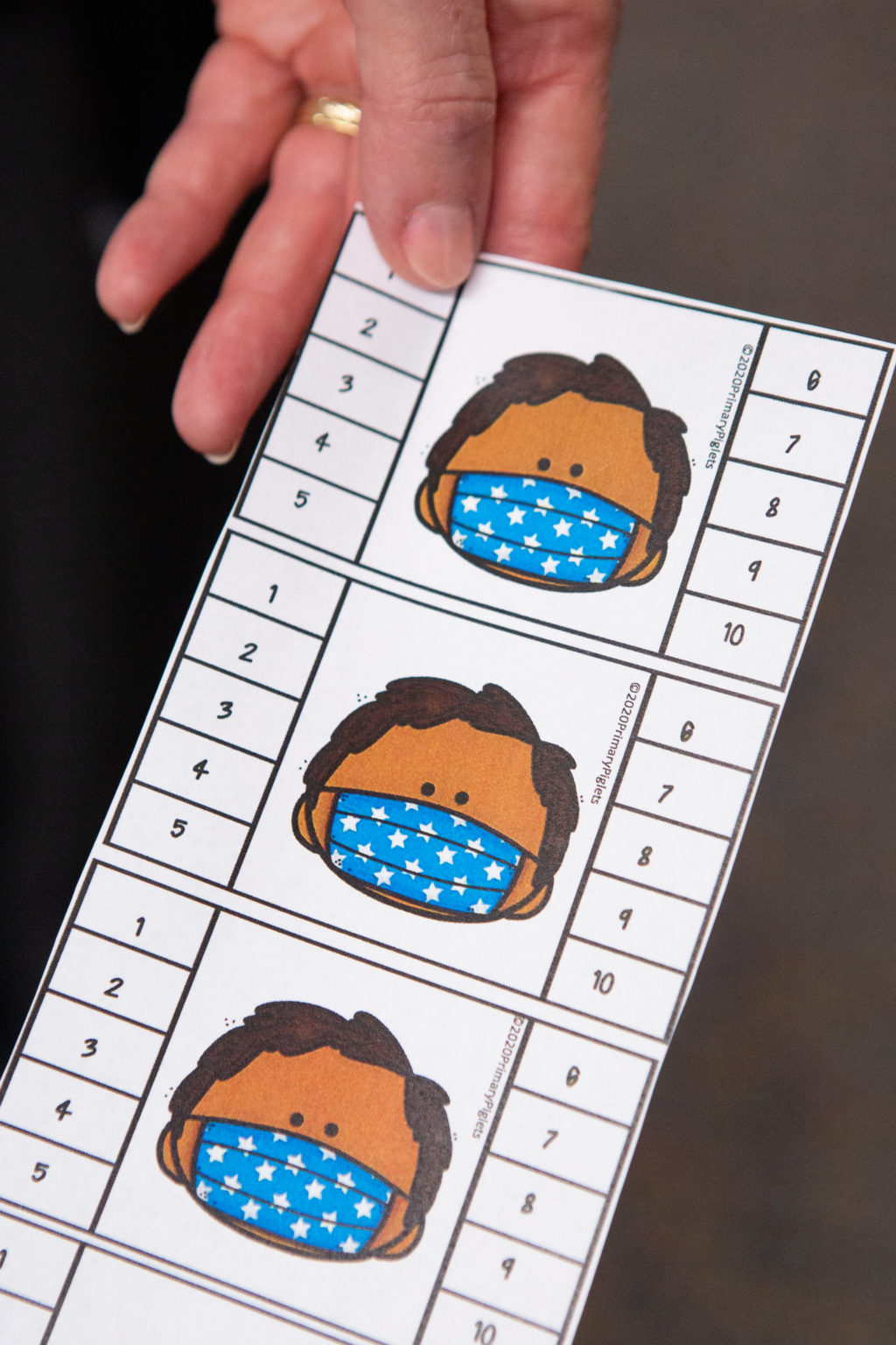 Una tarjeta con una imagen de caricatura de una persona que lleva una máscara facial con los números 1-10 alineando los lados de la tarjeta.
