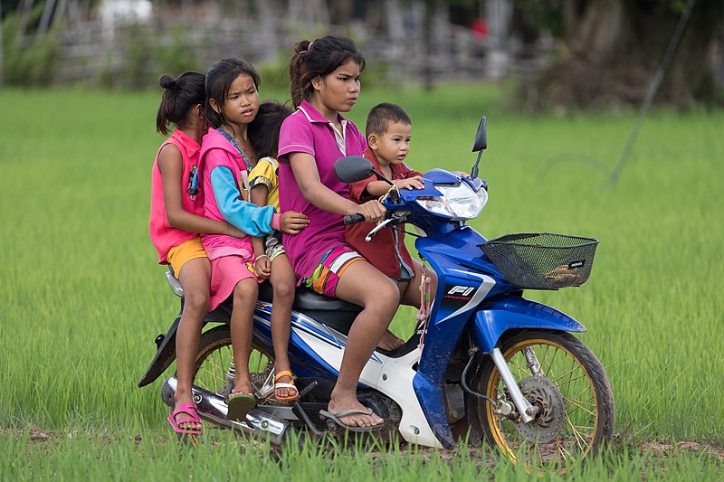 Five children riding on a motorcycle. 