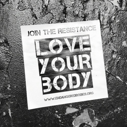 sign that reads 'Join the resistance, love your body, www.endangeredbodies.org'