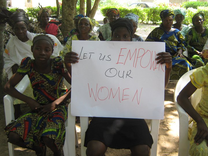 woman with sign that reads 'Let us empower our women'
