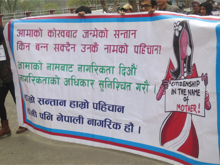 Figura 4.1. Manifestantes portan una pancarta durante una marcha del Día de los Derechos Humanos. Los lemas en la pancarta dicen “Los niños nacen del vientre de sus madres. ¿Por qué no pueden obtener identidad de sus nombres? Dar la ciudadanía a nombre de la madre, asegurar los derechos de ciudadanía” y “Nuestros hijos, nuestra identidad, también somos ciudadanos nepalíes”. Bhrikuti Mandap, Katmandú, 10 de diciembre de 2014. Dannah Dennis; CC BY.