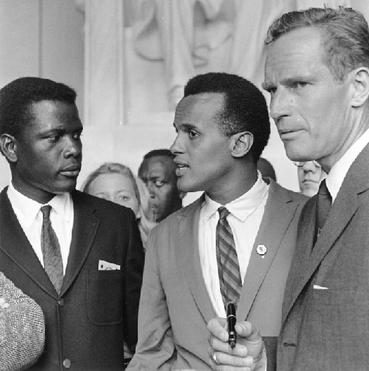 Uma foto de três ativistas dos direitos civis, da esquerda para a direita, Sidney Poitier, Harry Belafonte e Charlton Heston.