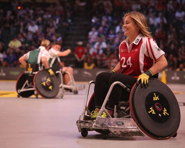 Una mujer en silla de ruedas está jugando básquetbol.