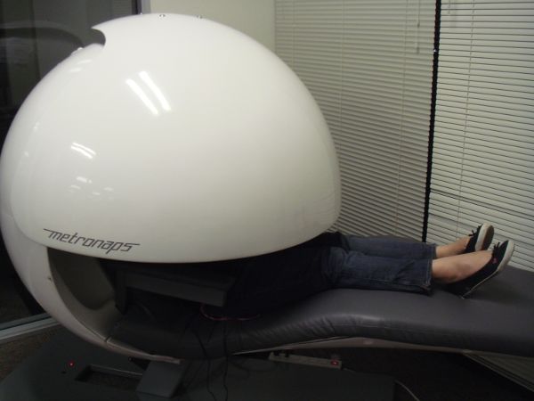 Una persona tomando una siesta dentro de una cápsula de siesta de Google.