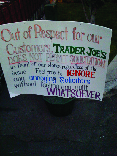 La photo d'un panneau. Le panneau indique : « Par respect pour nos clients, Trader Joe's n'autorise pas la sollicitation devant nos magasins, quel que soit le problème. N'hésitez pas à ignorer tout avocat agaçant sans vous sentir la moindre culpabilité ».