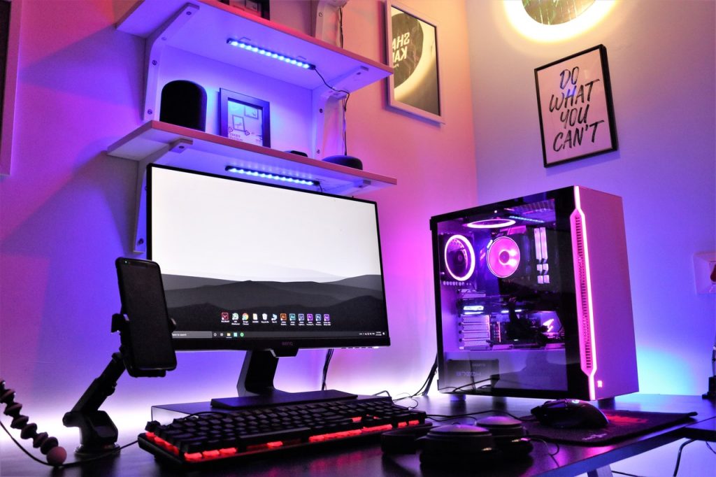 A gaming computer with colorful LEDs and backlit gaming setup