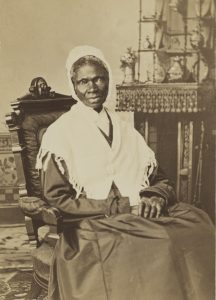 Sepia image of Sojourner Truth sitting in a chair with a white shawl.