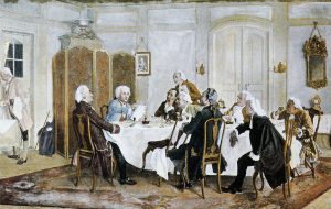 Nine men wearing white wigs sitting around a table debating each other. There is one person who appears to be a servant in the corner.