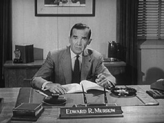 Une image d'Edward R. Murrow assis derrière un bureau.