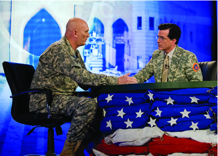 Image de Stephen Colbert et Ray Odierno assis de part et d'autre d'une table, face à face.
