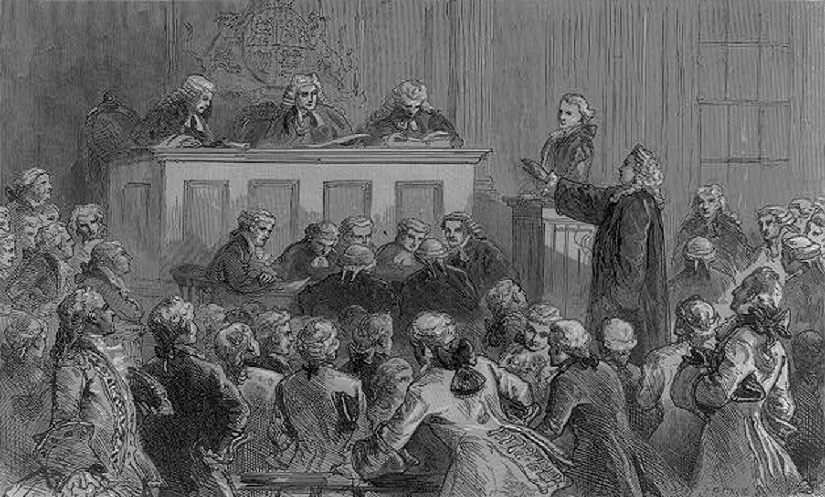 رسم توضيحي للعديد من الرجال في قاعة المحكمة. يقف رجل ويده ممدودة في مواجهة القاضي.