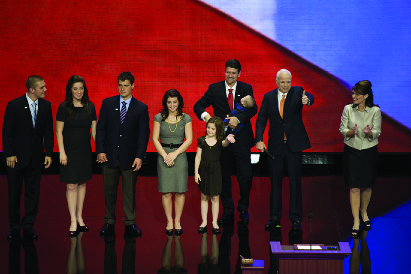 Une image de Sarah Palin sur scène avec John McCain et plusieurs autres personnes.