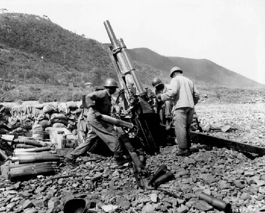 几名士兵围绕一门大炮的照片。