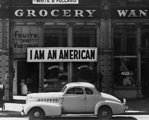 Uma foto de uma placa na fachada de uma loja que diz “Eu sou americano”.