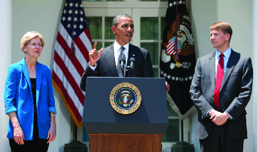 Photo du président Barack Obama s'exprimant sur une tribune avec Elizabeth Warren à sa gauche et Richard Cordray à sa droite.