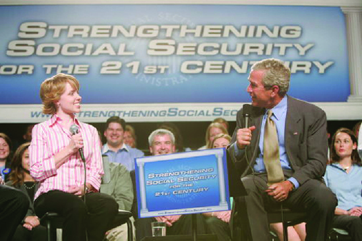 Une photo de George W. Bush prenant la parole lors d'un événement. La banderole derrière lui dit « Renforcer la sécurité sociale pour le 21e siècle ».