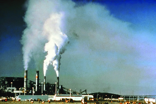 Uma imagem de uma usina com grandes colunas de fumaça saindo de suas quatro torres.