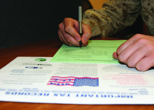 Uma imagem da mão de uma pessoa segurando uma caneta sobre um formulário.