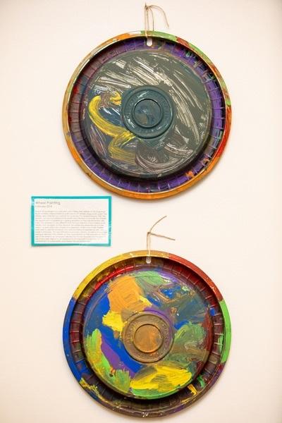 Two color wheel paintings hang on the wall.