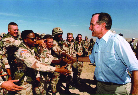 乔治 ·H.W. 布什在户外与美军握手。