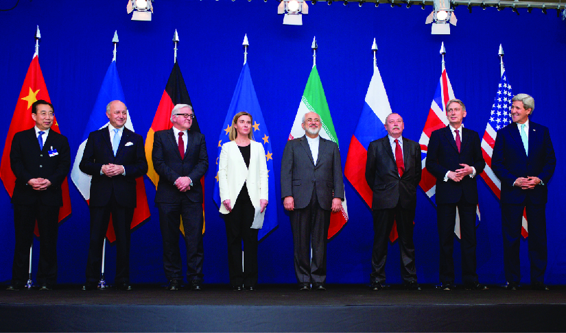 Uma imagem dos ministros das Relações Exteriores e outras autoridades em pé em um palco, cada um em frente à bandeira de seu país.