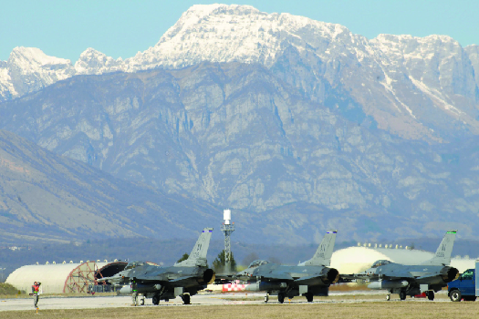 Image de plusieurs avions de chasse échoués, avec une chaîne de montagnes en arrière-plan.