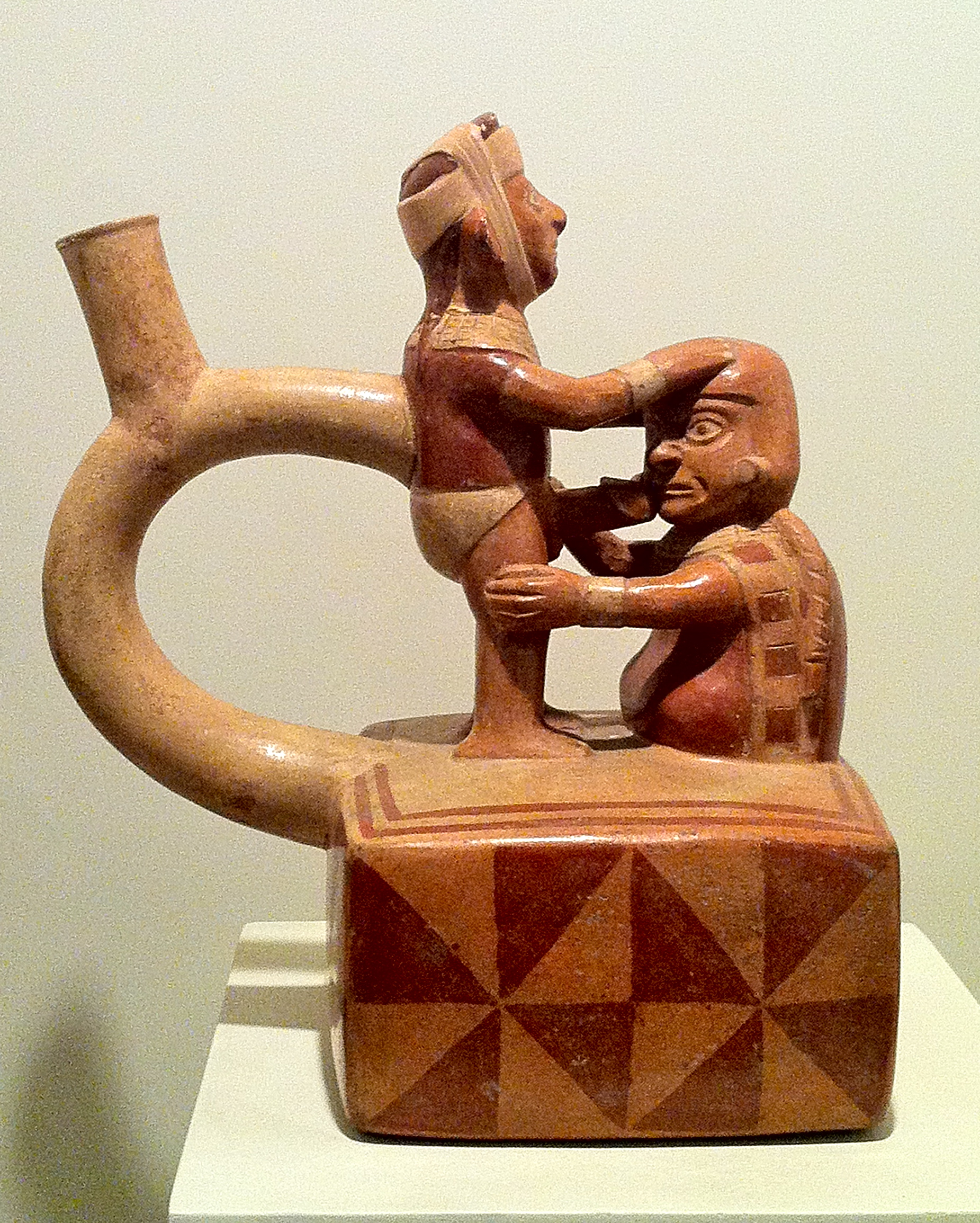 Pottery vessel that depicts two figures, one kneeling by a phallic image.