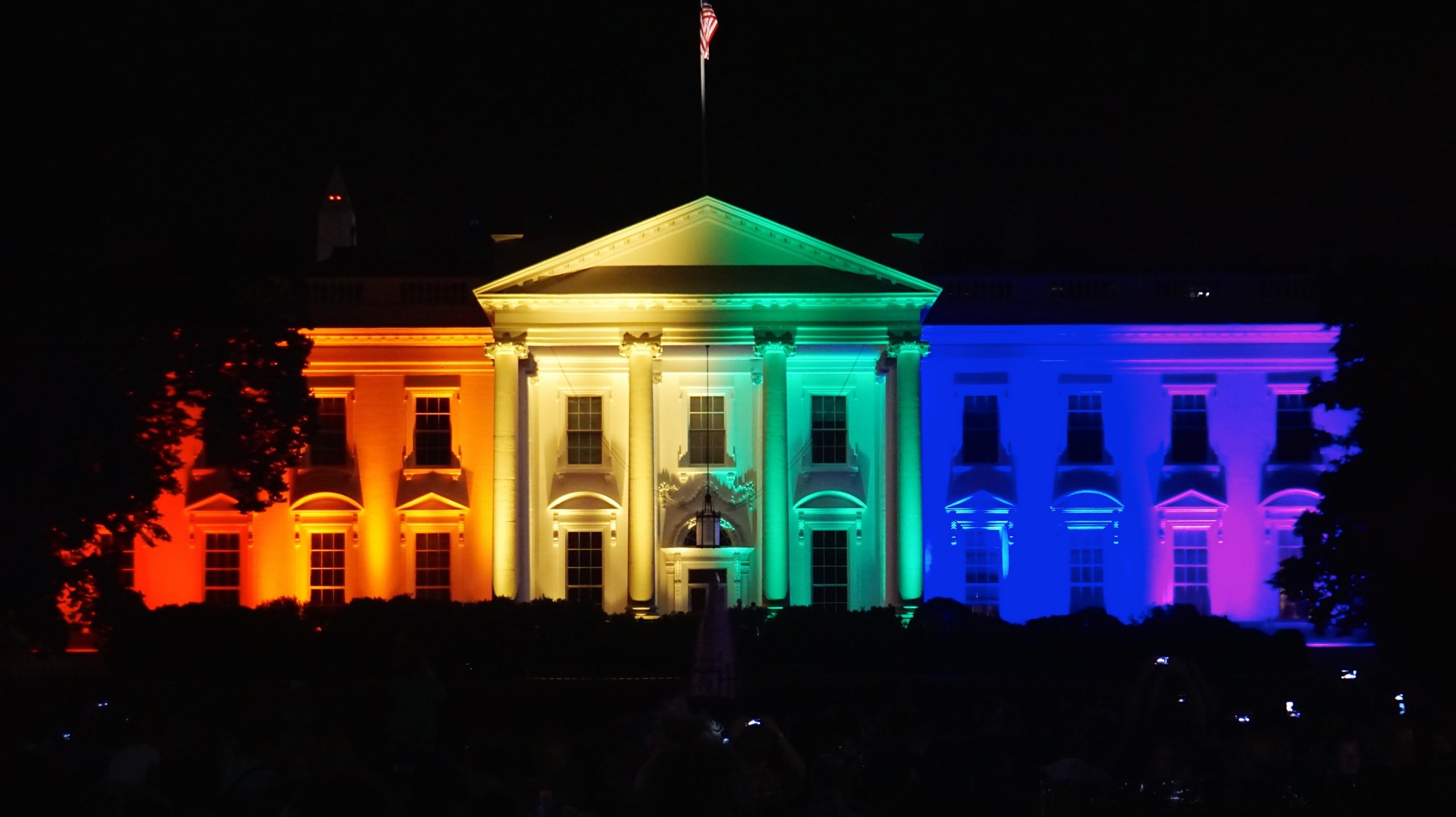 A photo of the White House illuminated in rainbow colors.