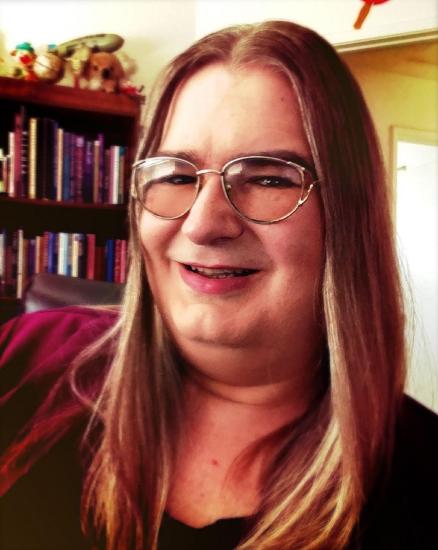 A woman looks at the camera, smiling.