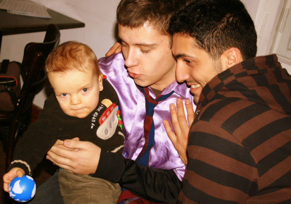 Two men holding their son.