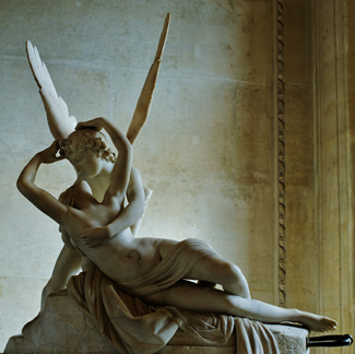 一张照片显示了一个有翅膀的男人从后面拥抱一个女人的雕塑。