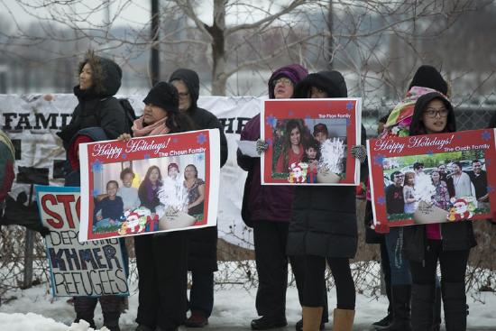 protesters gathering in the snow with signs calling an end to deportation 