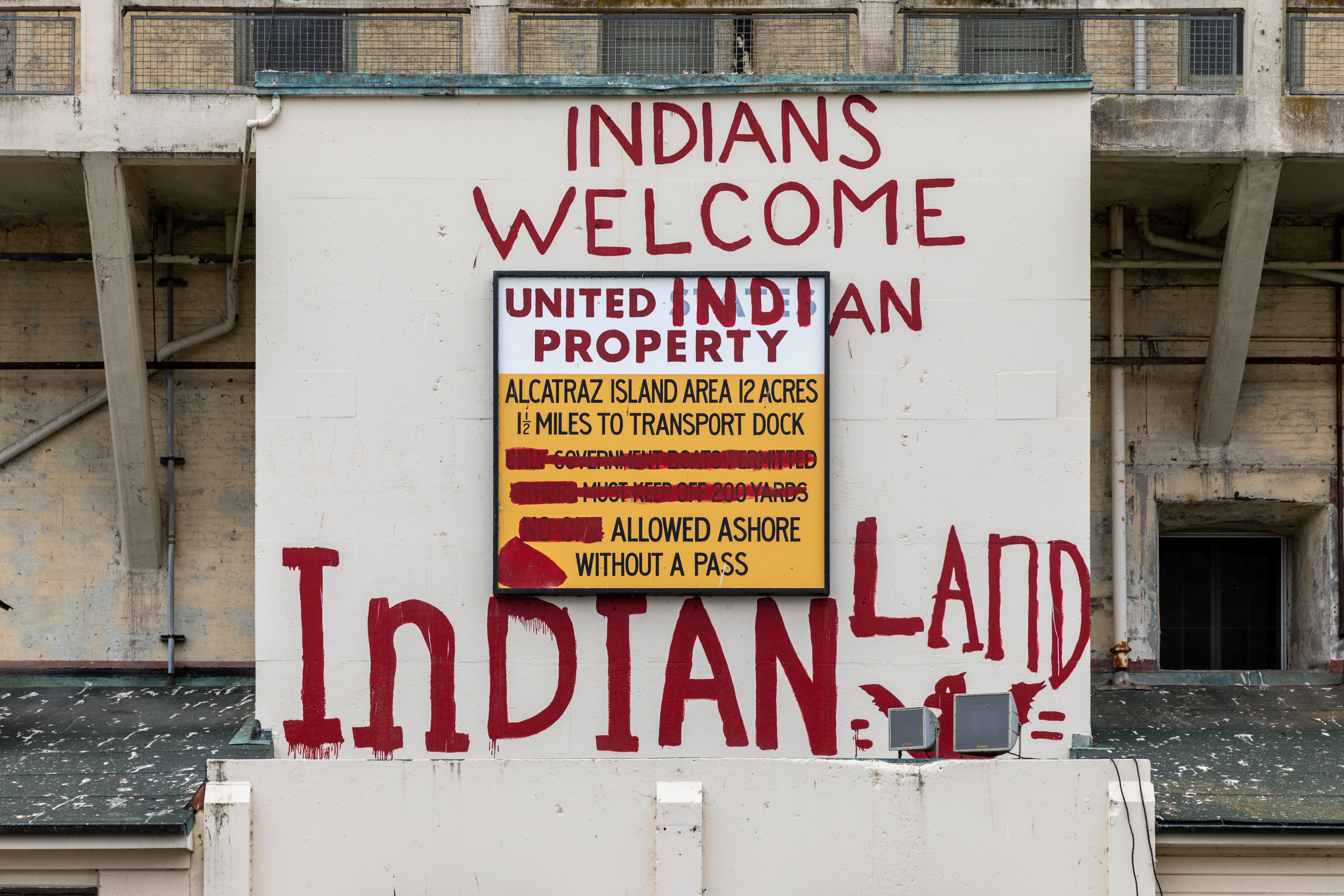 wall with phrases painted in red: "Indians Welcome" "United Indian Property" and "Indian Land'