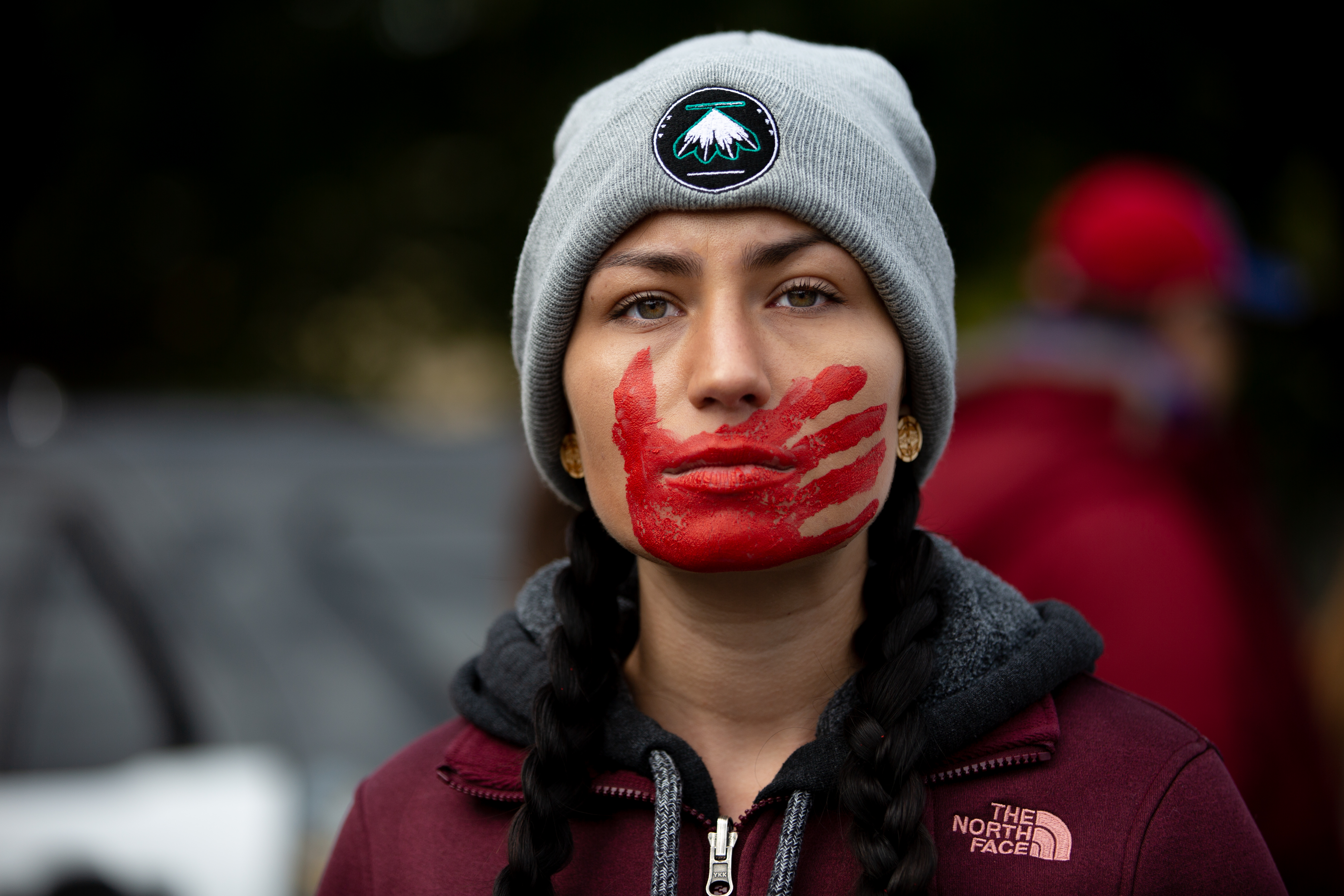 A participant at the Greater Than Fear Rally Rochester Minnesota with a red hand painted across her face