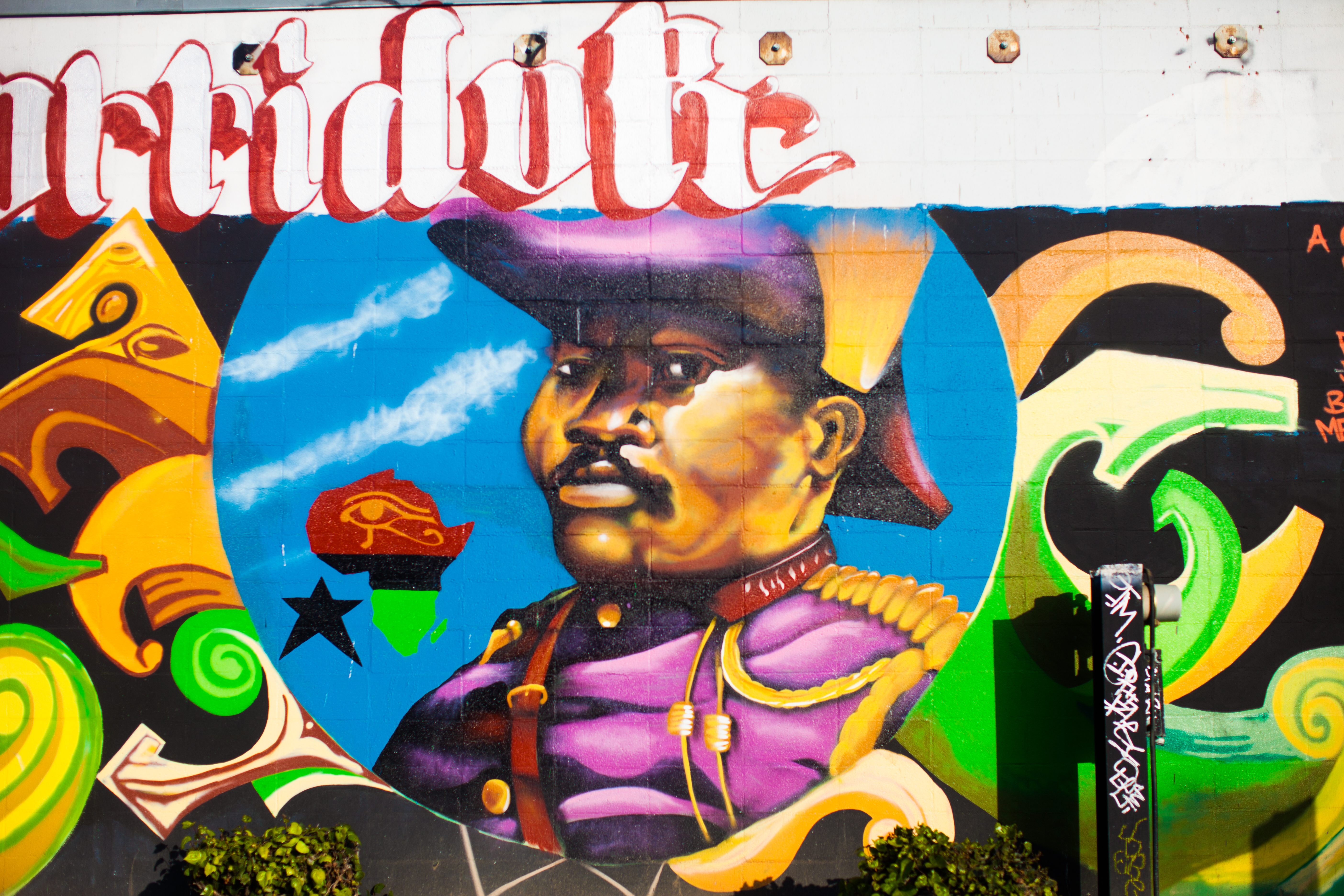 Marcus Garvey's mural in Oakland, California, sporting a military officer’s outfit in royal purple hue