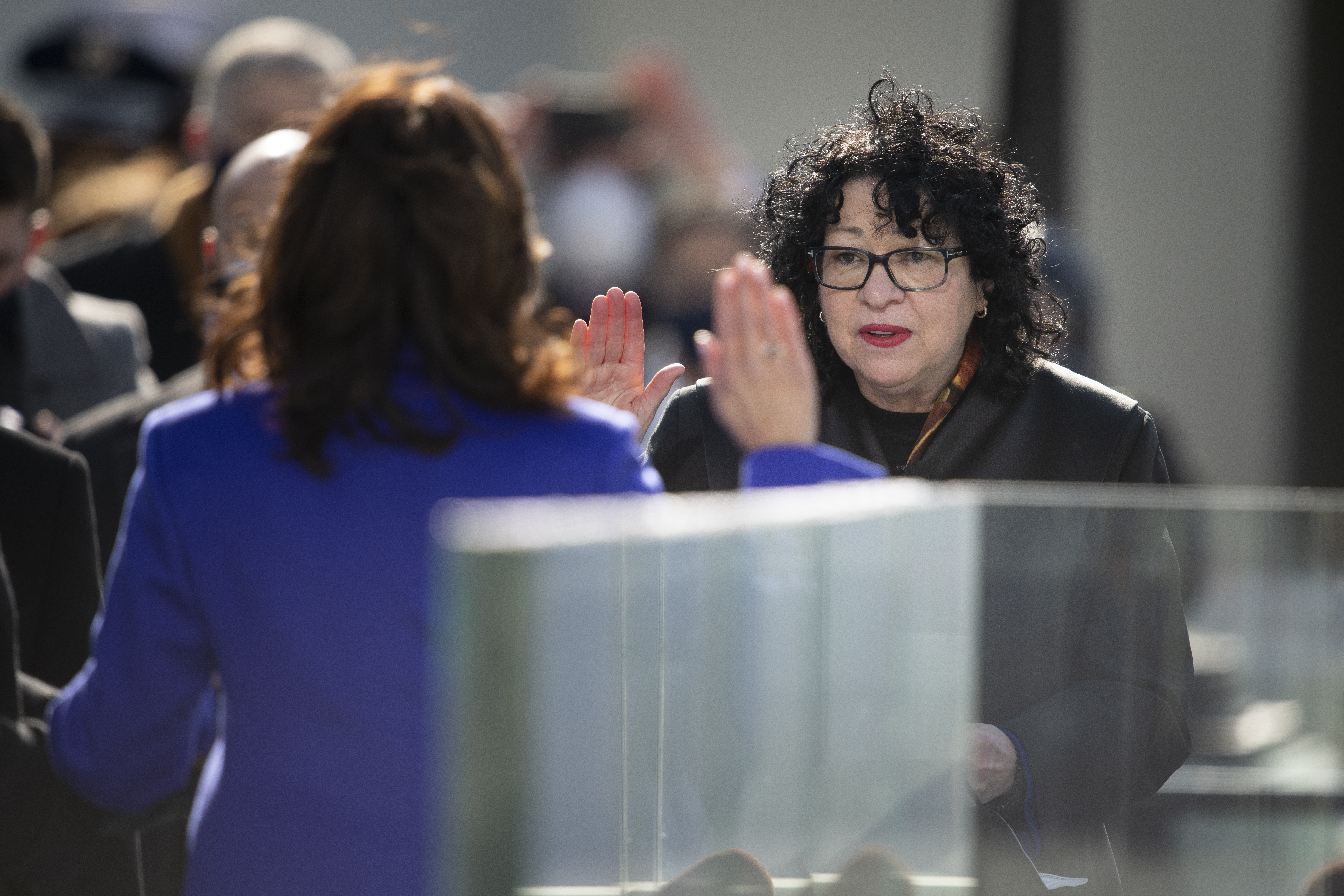 Supreme Court Justice Sonia Sotomayor in a black robe, with Vice President Kamala Harris facing away from the camera