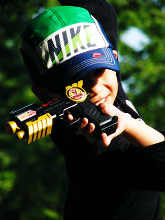 一张照片显示一个孩子指着玩具枪。