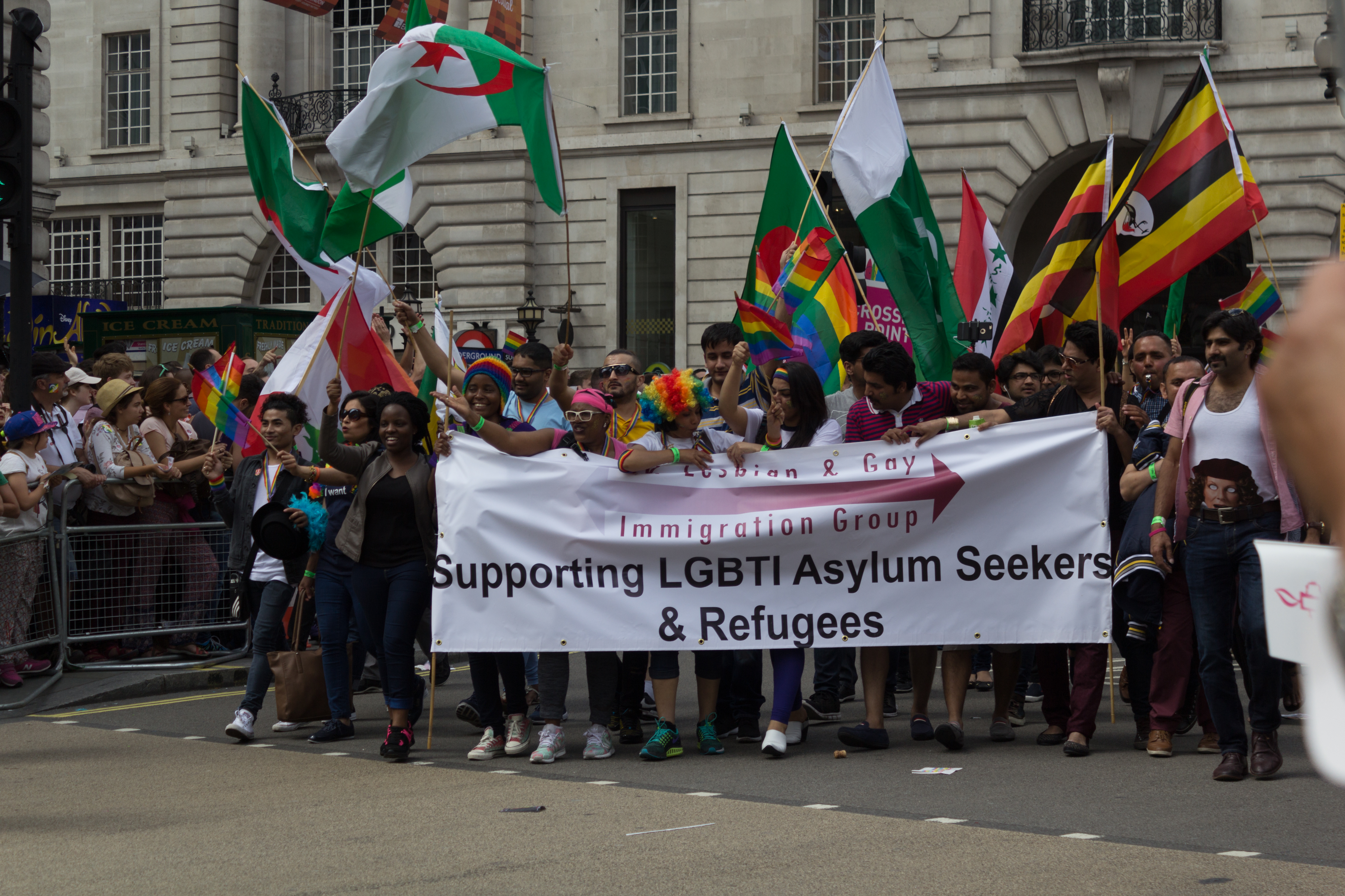 Activists holding a banner that reads, “Lesbian and Gay Immigration Group: Supporting LGBTI Asylum Seekers and Refugees”
