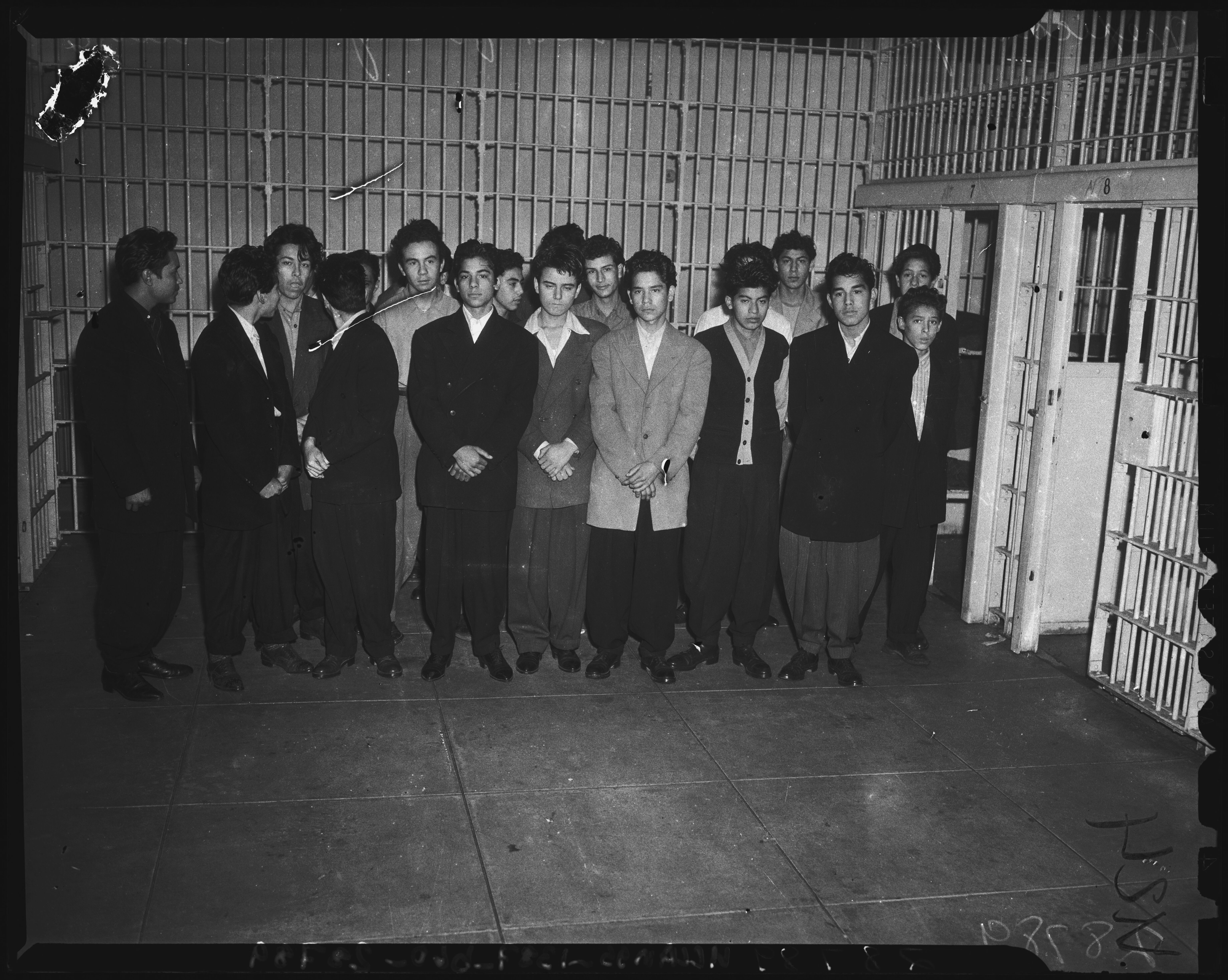A group of about twenty teen boys being held in a cell