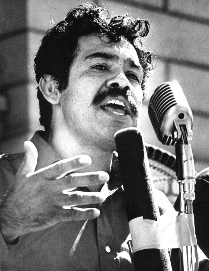 Corky Gonzalez speaking in front of a microphone